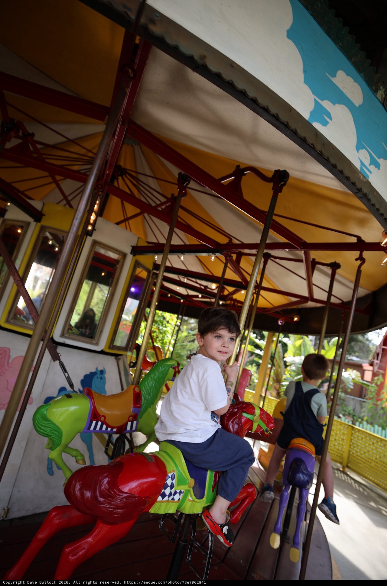 Boy Enjoying Colorful Carousel Ride at Fantasyland