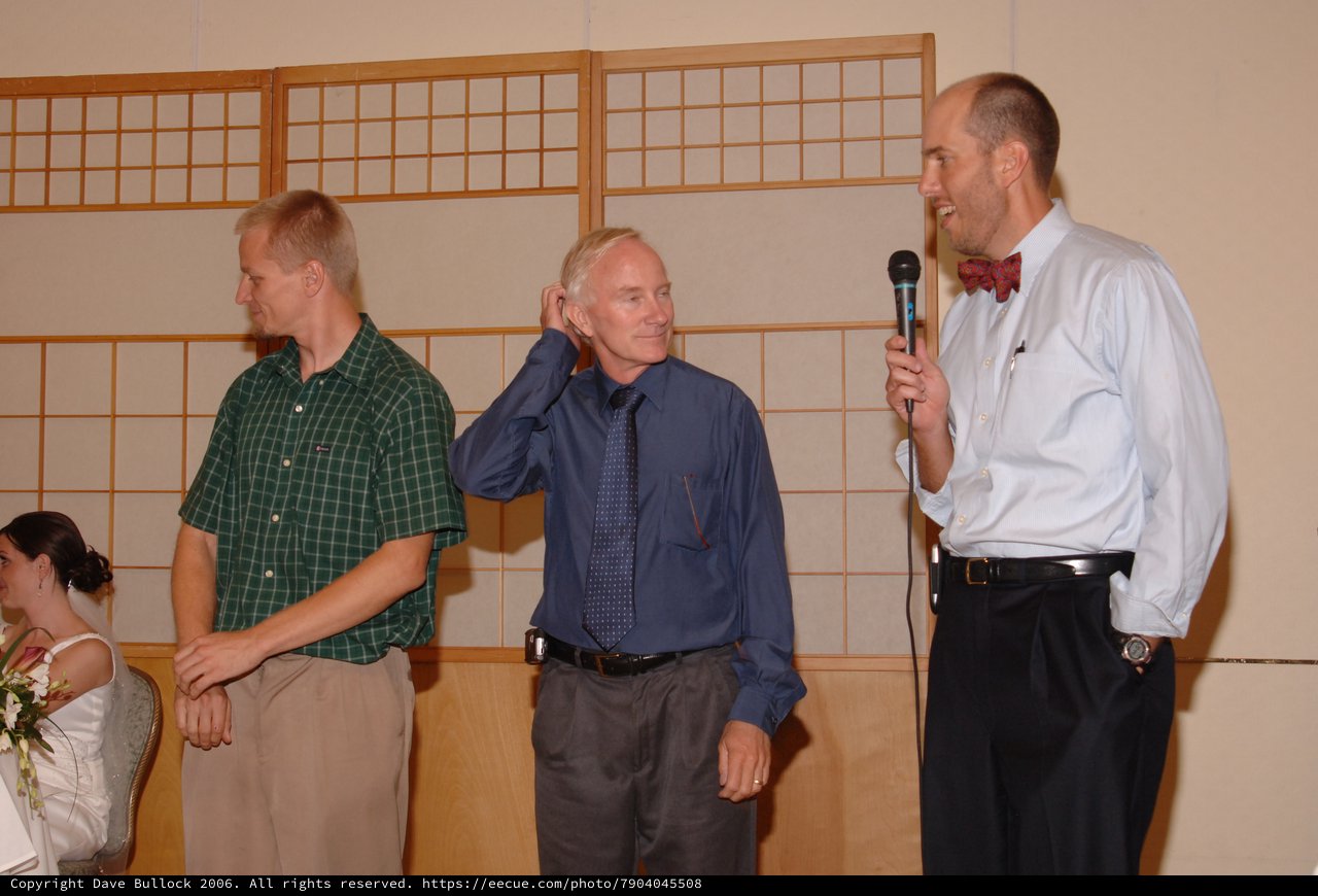 Three Men Share a Moment at Wedding Reception