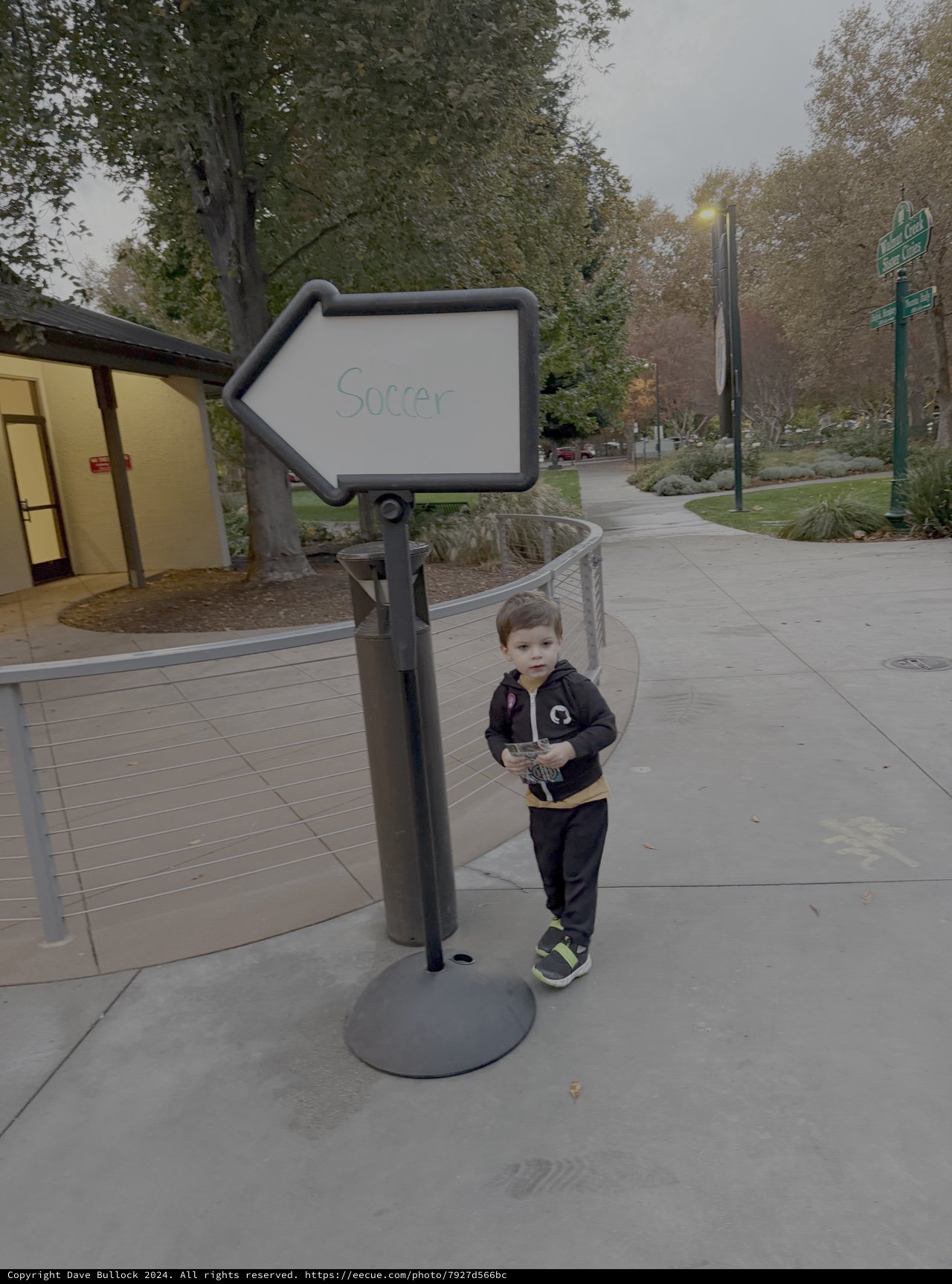 Young Child Playing Near Soccer Direction Sign