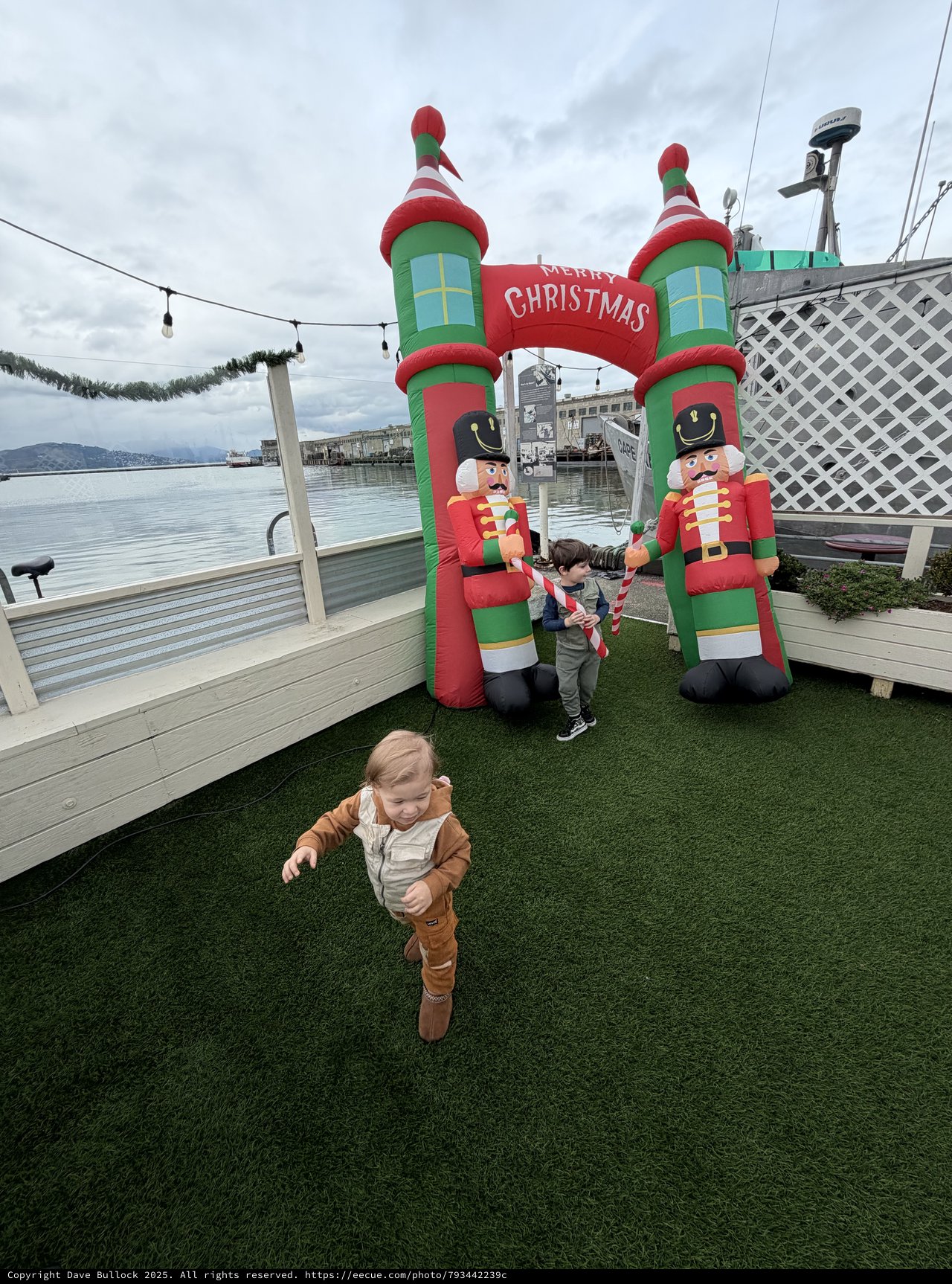 Children Playing Near Inflatable Christmas Decorations by the Water