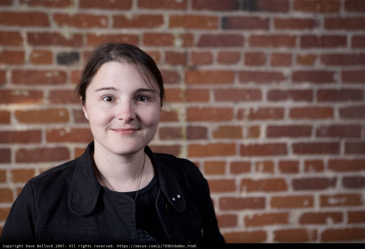 Black Jacket Poses in Front of Brick Wall