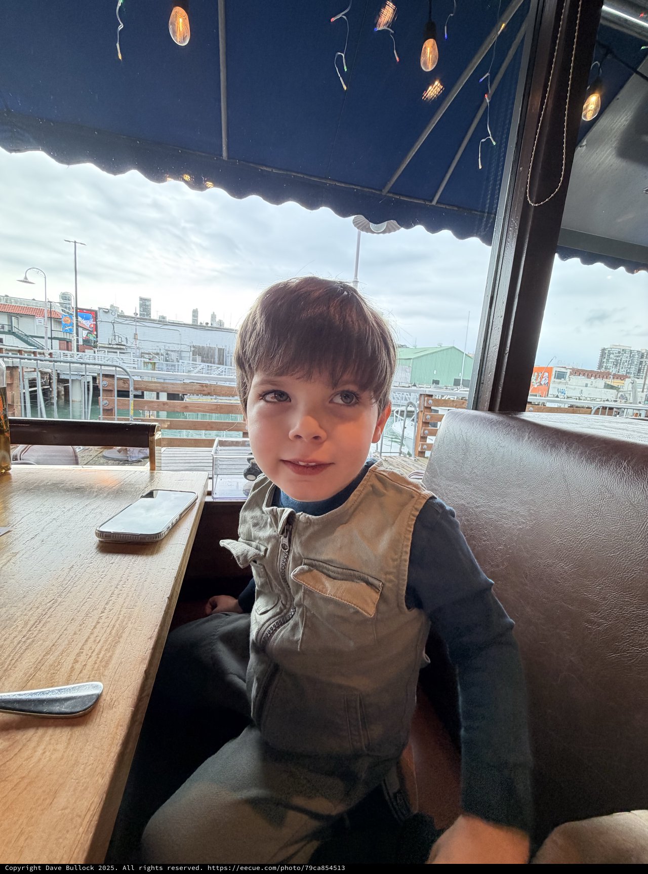 Young Boy at Rooftop Cafe on Overcast Day