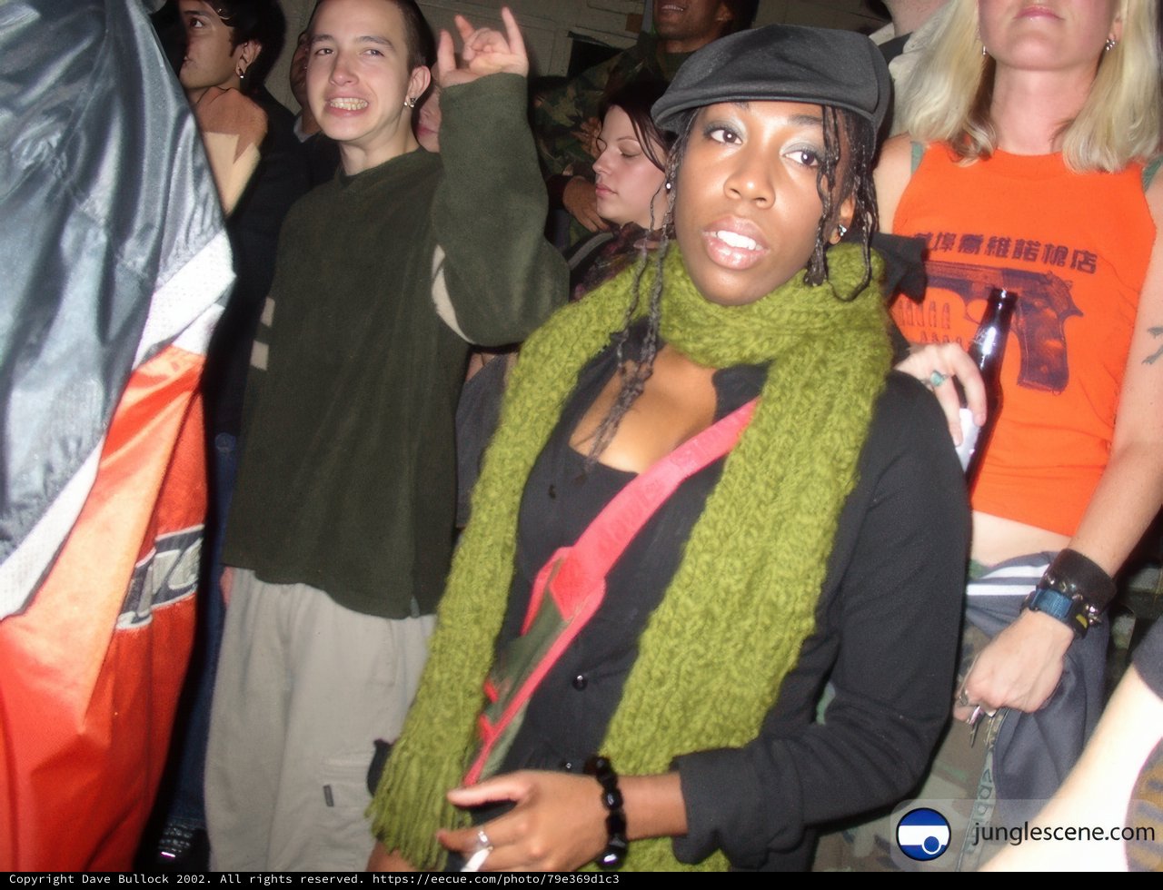Woman in Green Scarf Stands Out in Crowded City