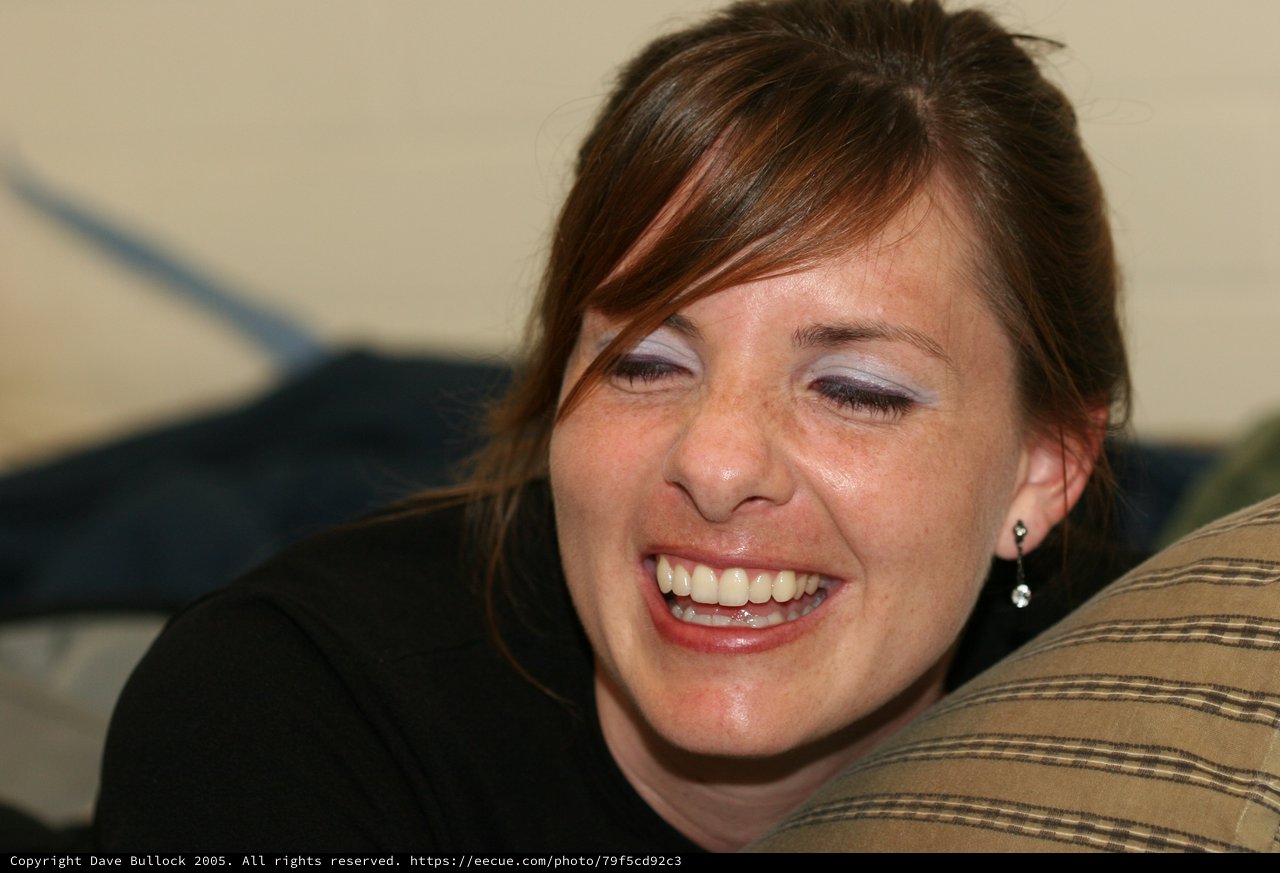 Joyful Woman Laughing Candidly at Indoor Gathering