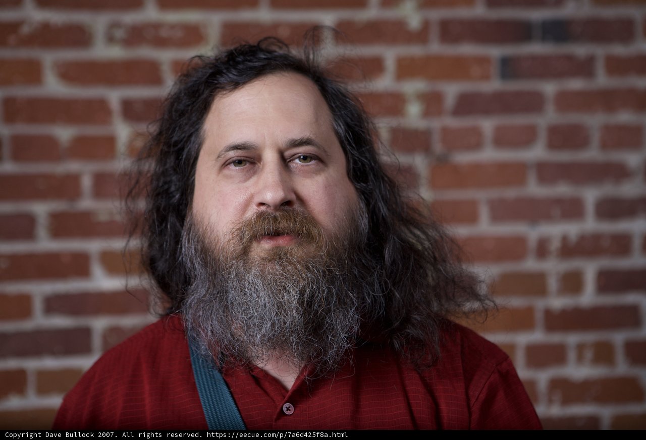 Richard Stallman posing in front of a brick wall