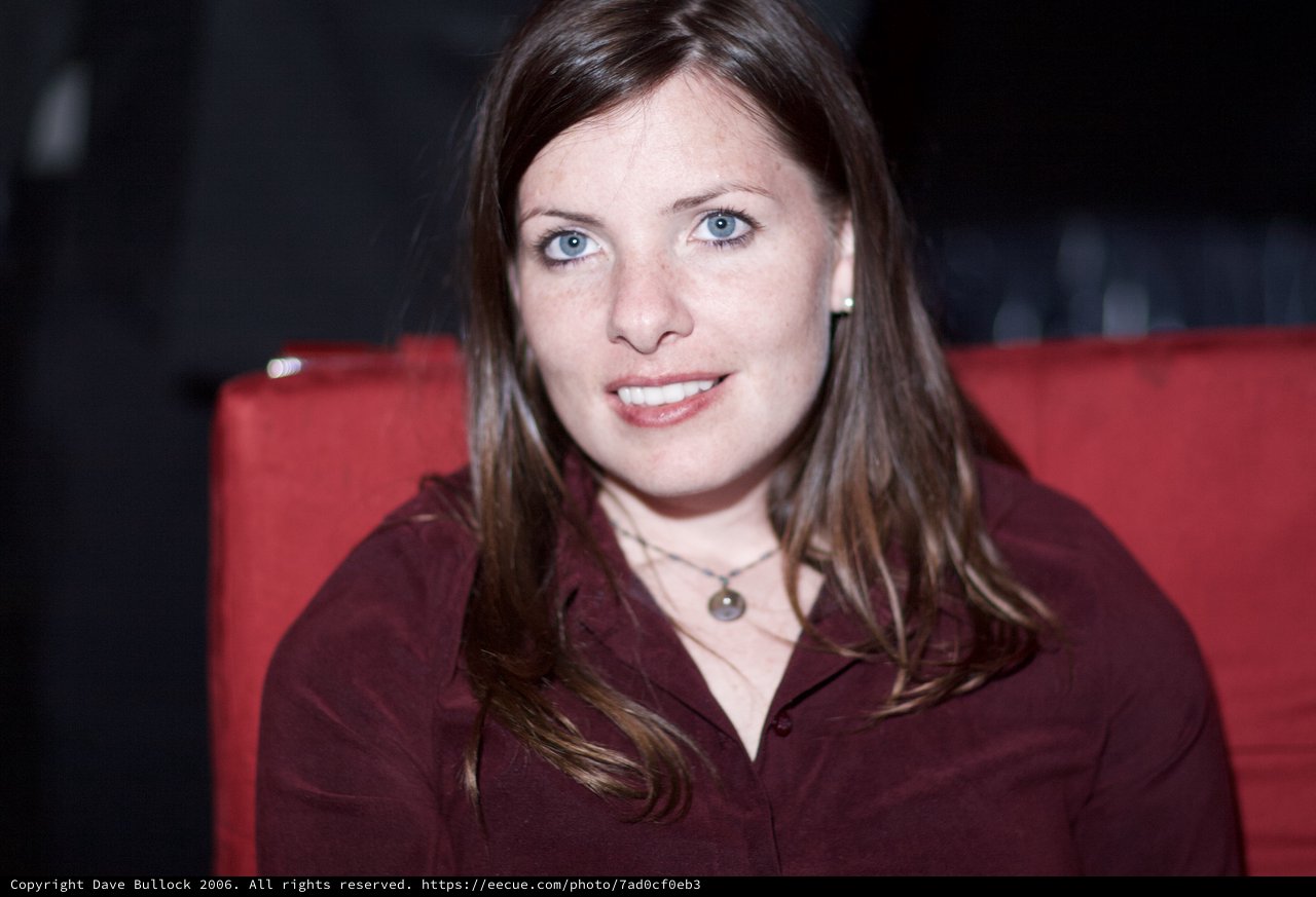 Smiling Woman with Blue Eyes in Red Chair