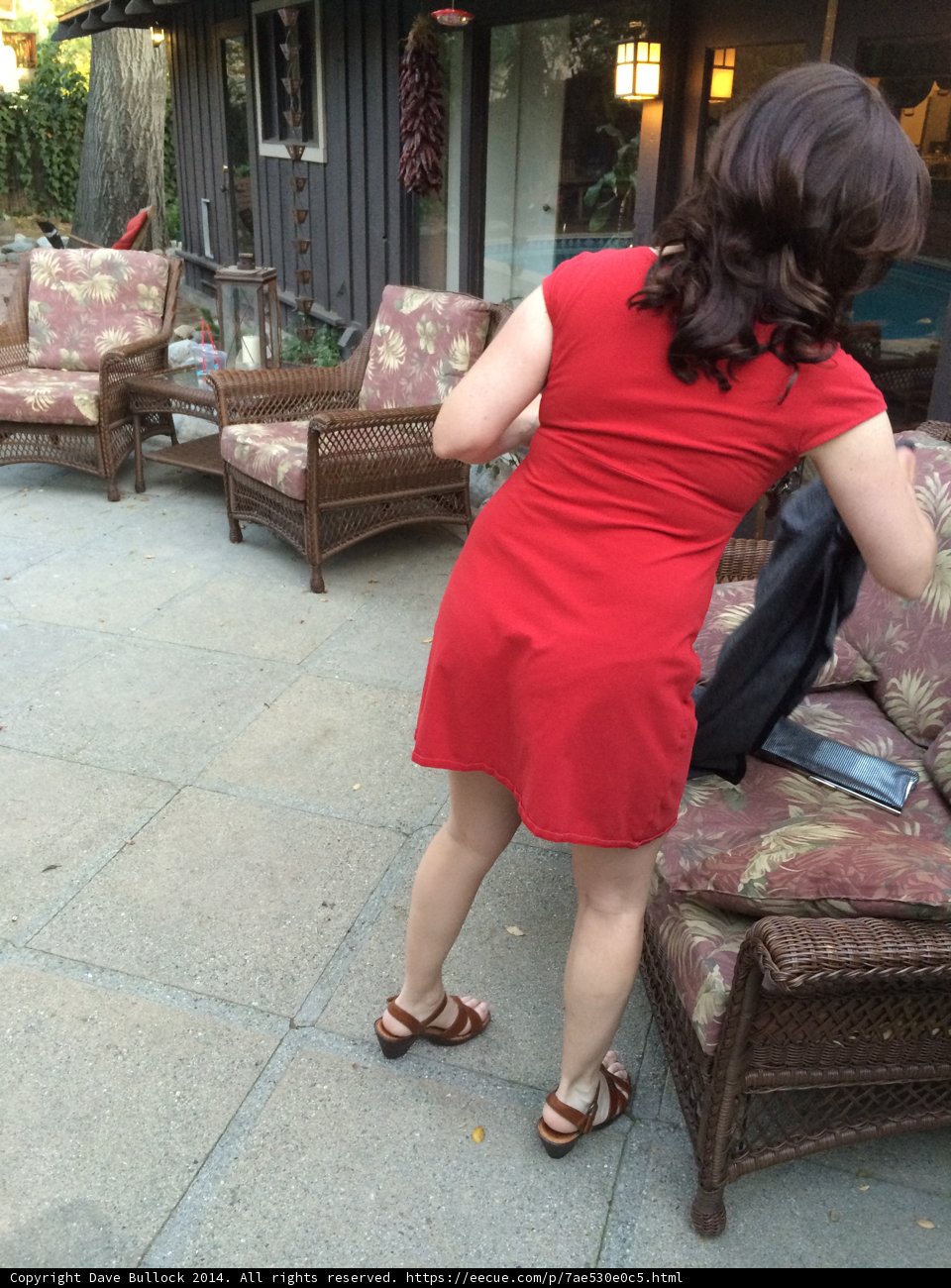 Woman in Red Dress Relaxing on Patio Couch