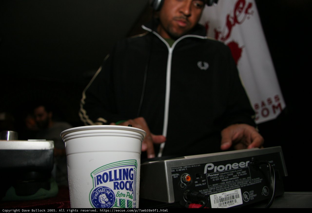 Black Jacketed Man Sipping from Coffee Cup with Headphones On