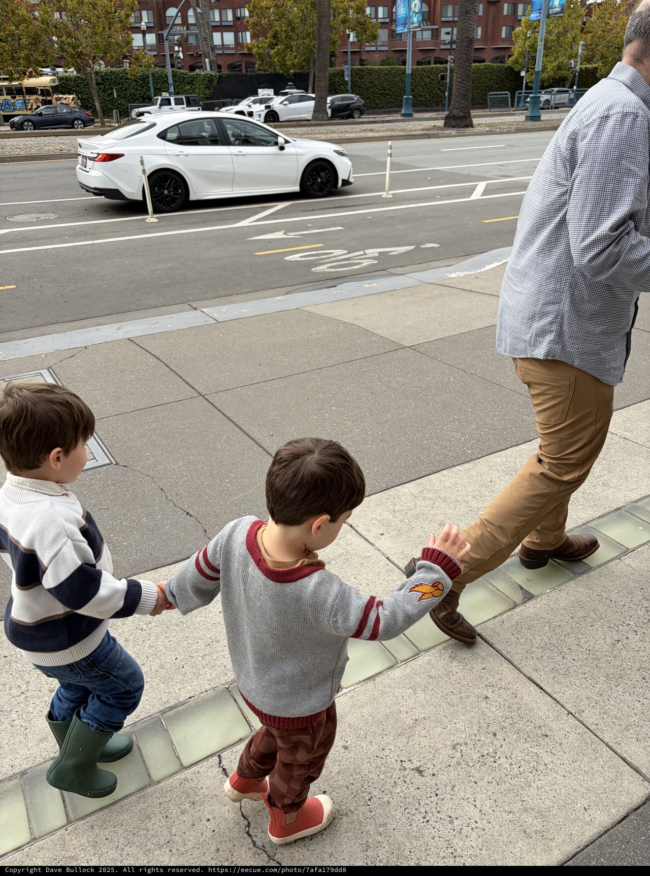 Father and Two Sons Walking on Urban Sidewalk