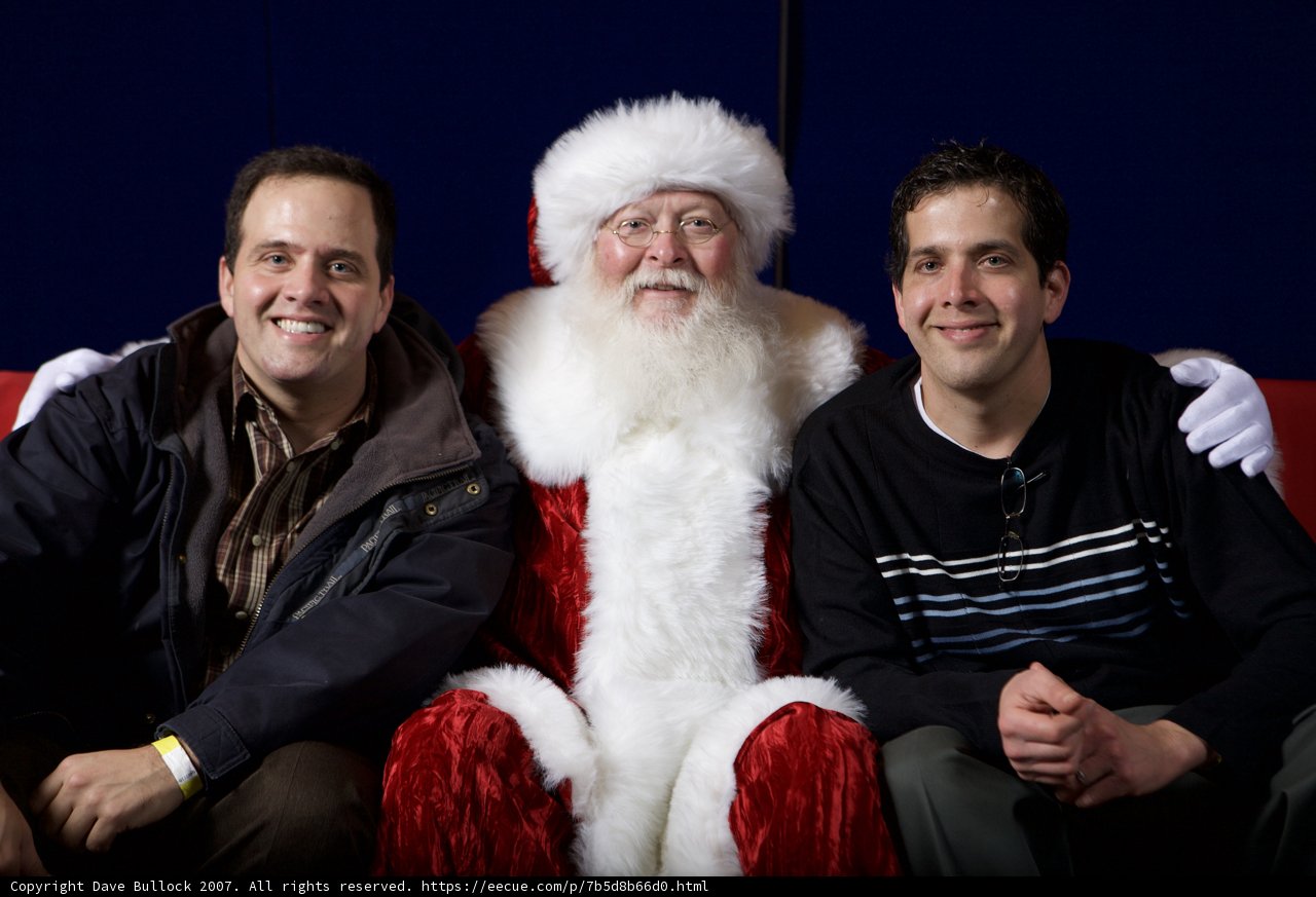 Three Men Strike a Pose with Santa Claus