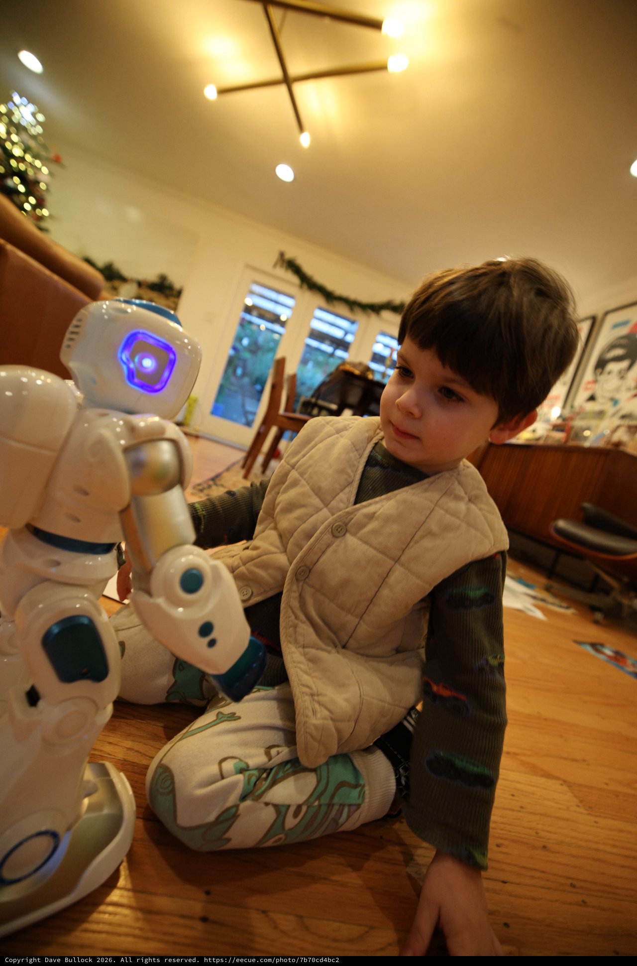 Child Interacting with White Humanoid Robot at Home