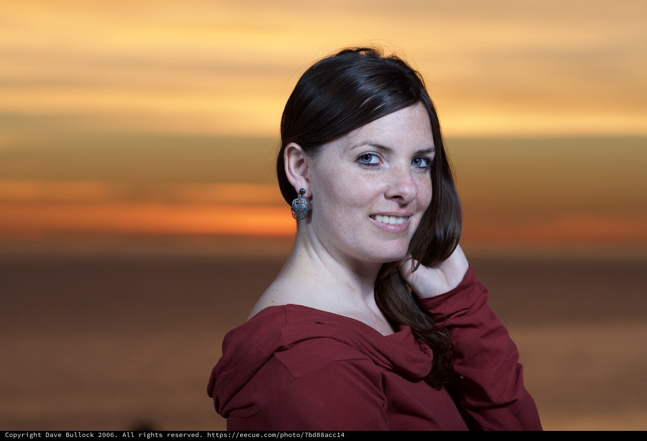 Dark-Haired Woman Smiling at Sunset by Sea