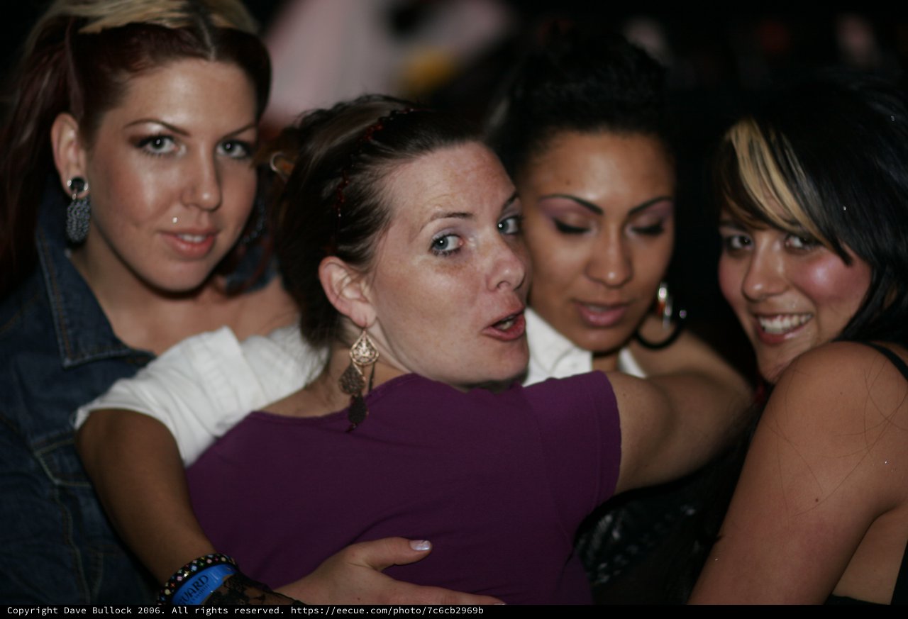 Four Women Crowding Together at Nightclub Party