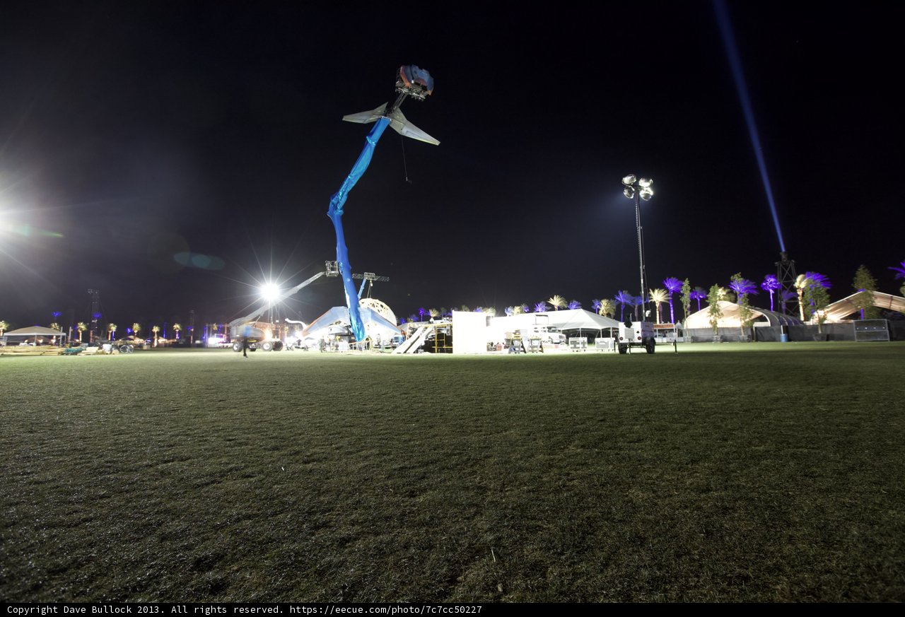 Illuminated Tent Amidst a Field of People and Cars