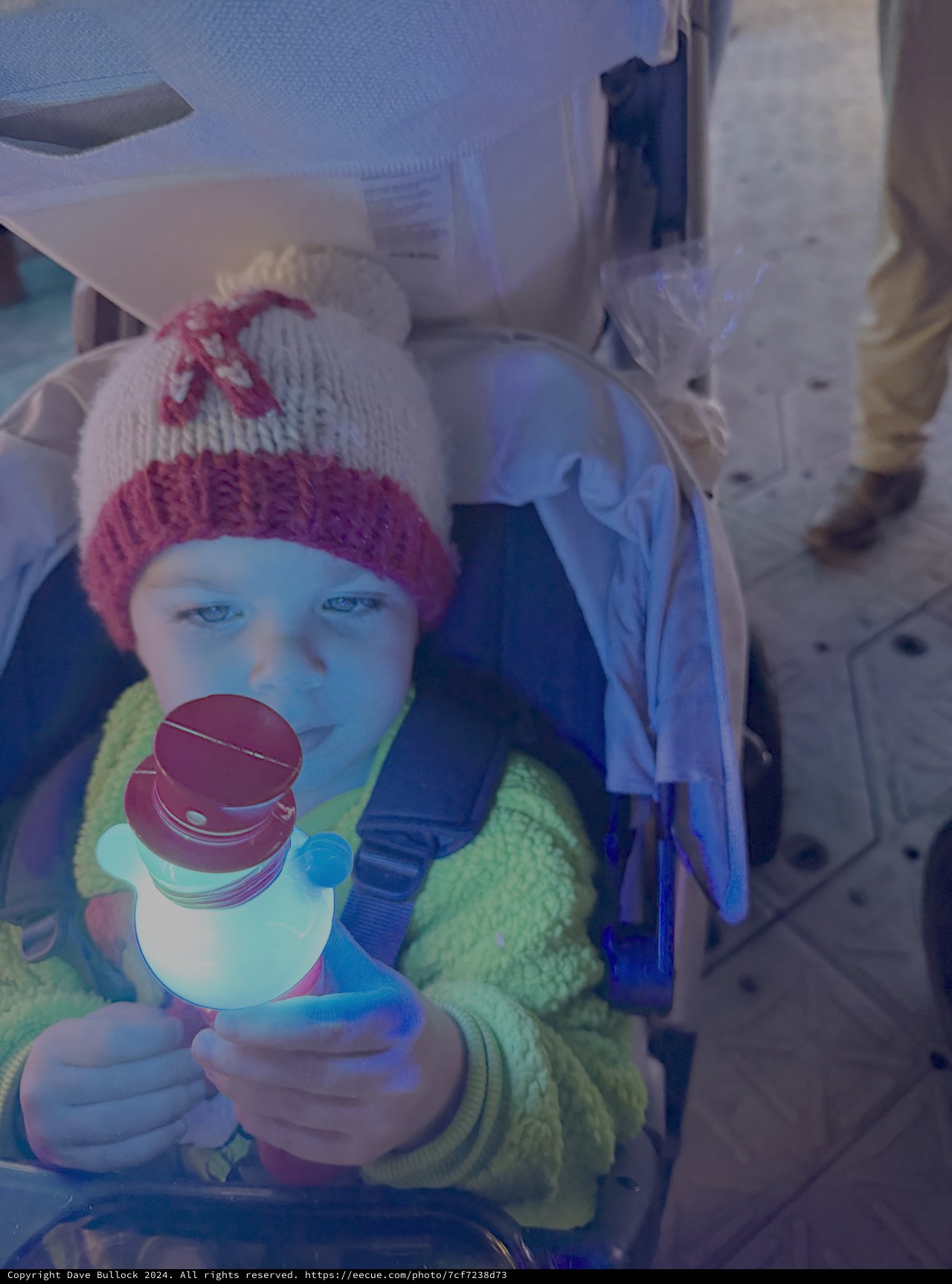 Child in Stroller Holding Colorful Winter Toy