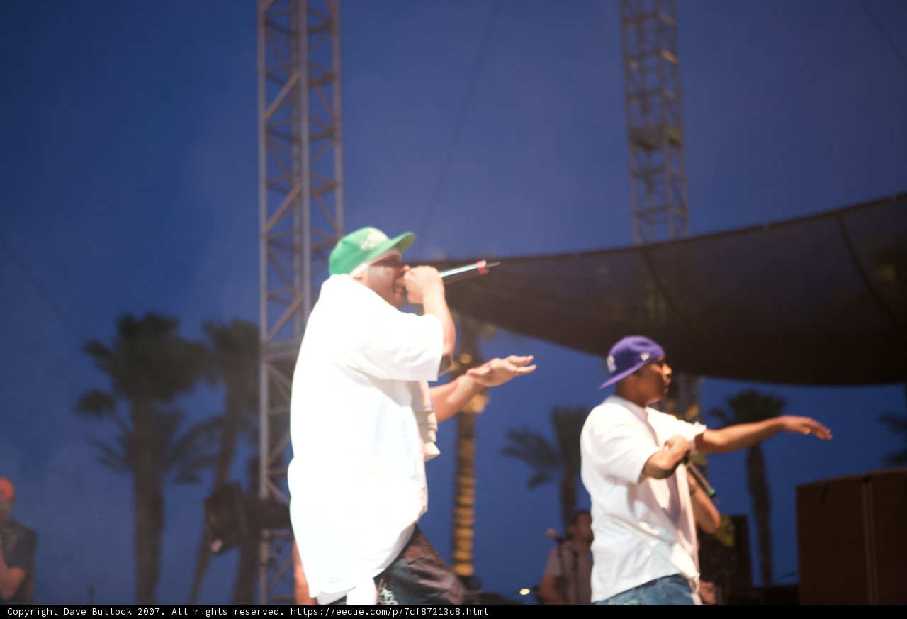 Two Men Performing on Stage Under Blue Skies
