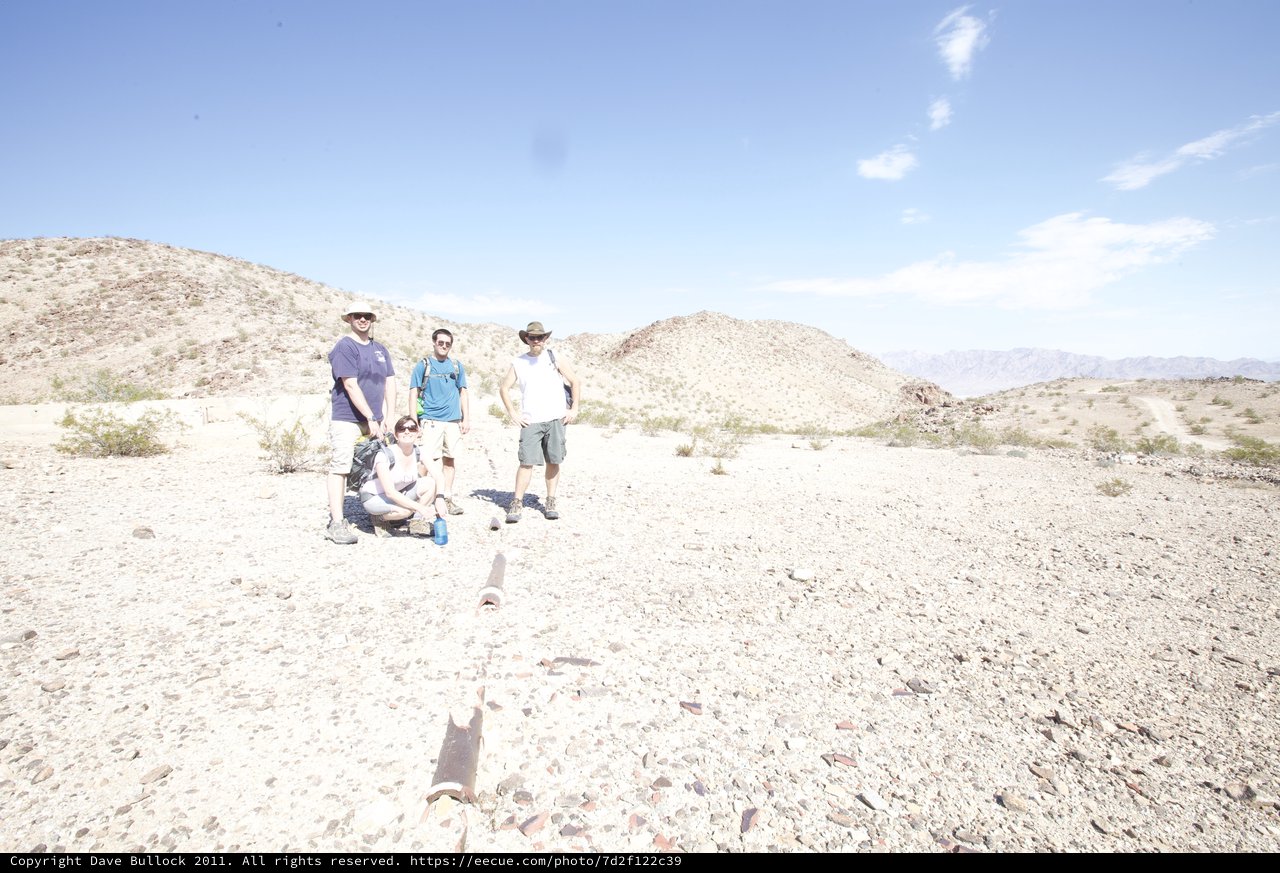 Desert Hikers Pause Among Arid Rocky Terrain