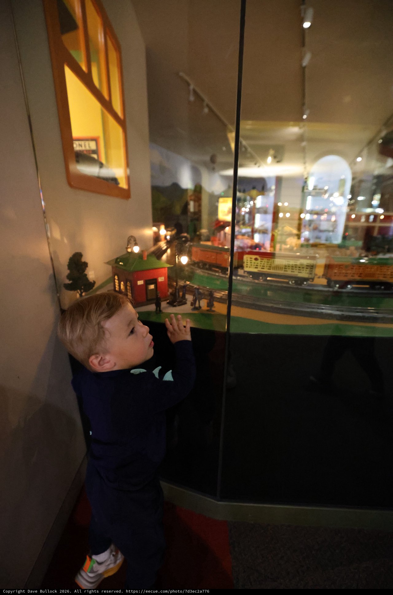 Young Boy Examining Model Train Display at Museum