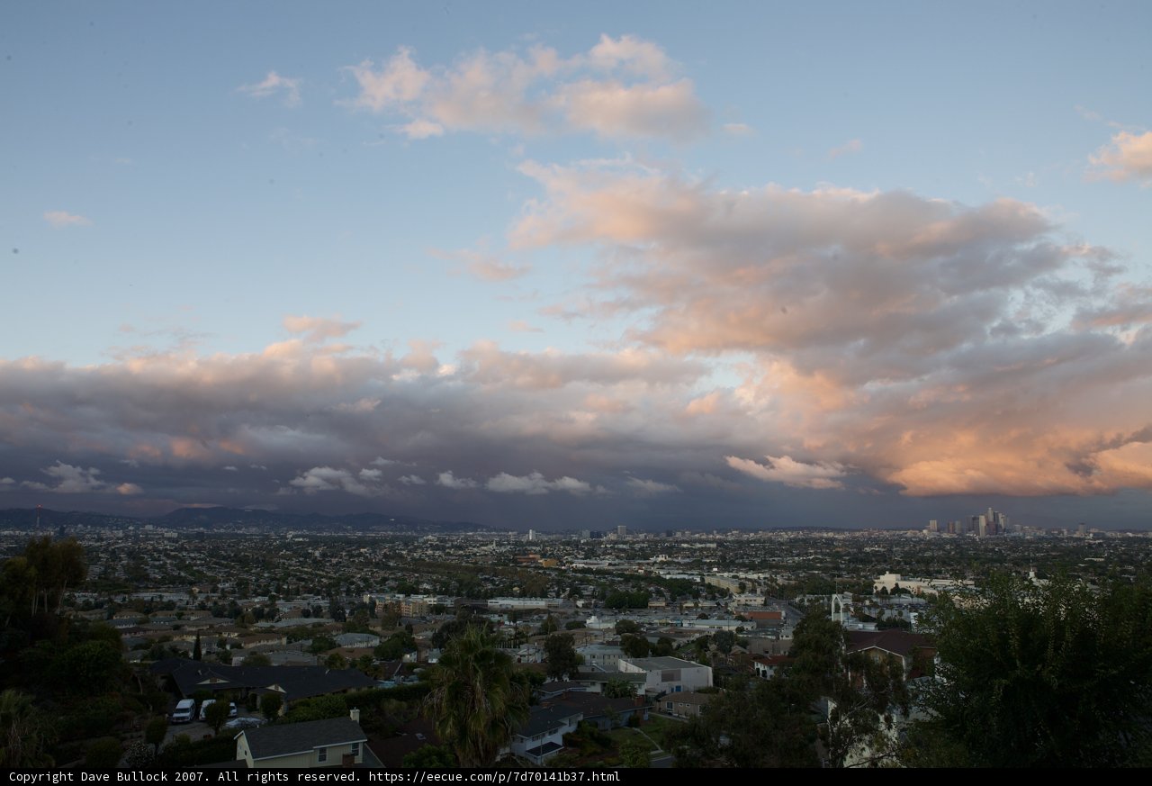 View of cityscape and cumulus clouds from a hill