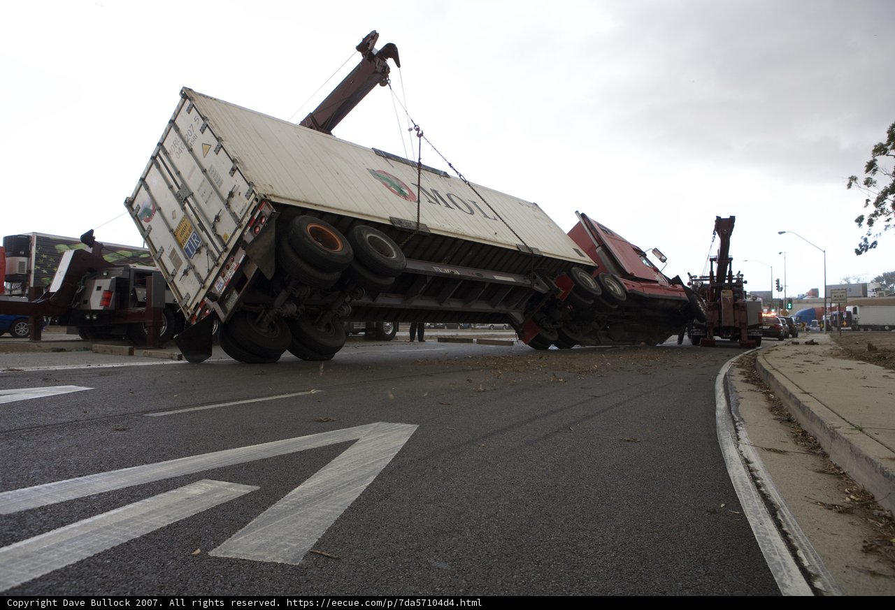 A Crane Lifts an Overturned Truck on Tarmac