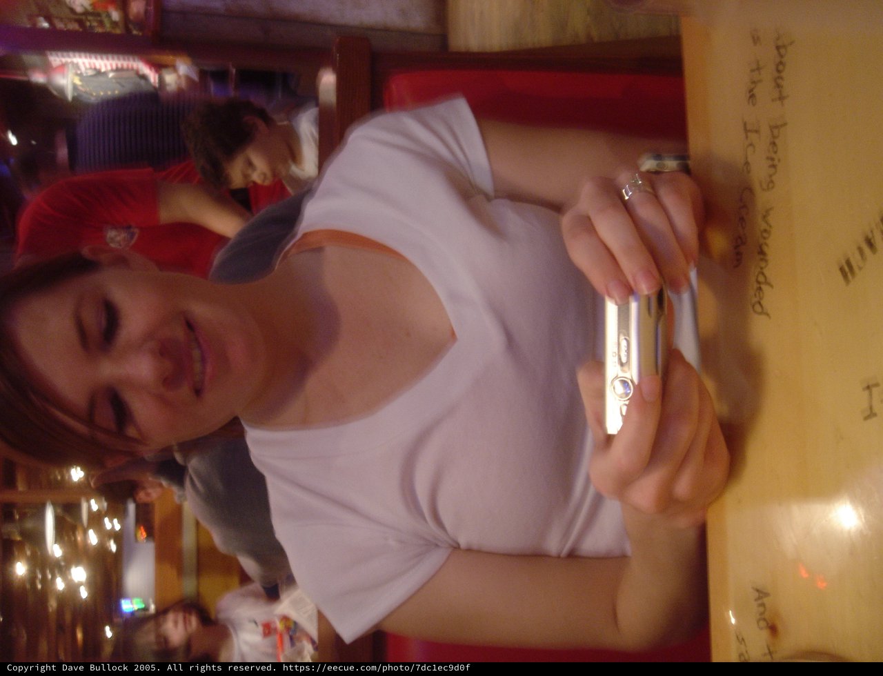 Woman Smiling with Compact Camera at Restaurant