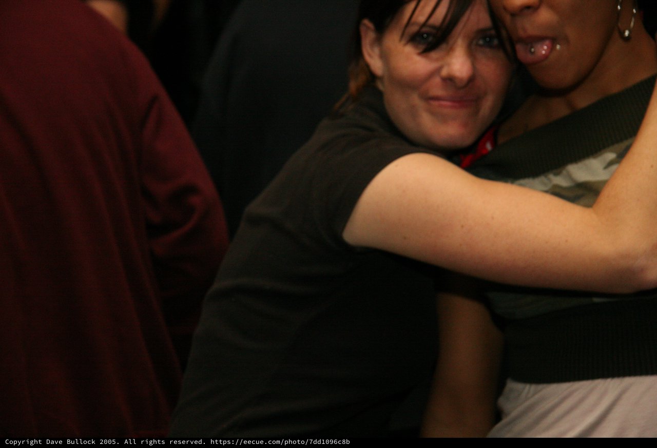Two Friends Embracing at a Dark Indoor Party
