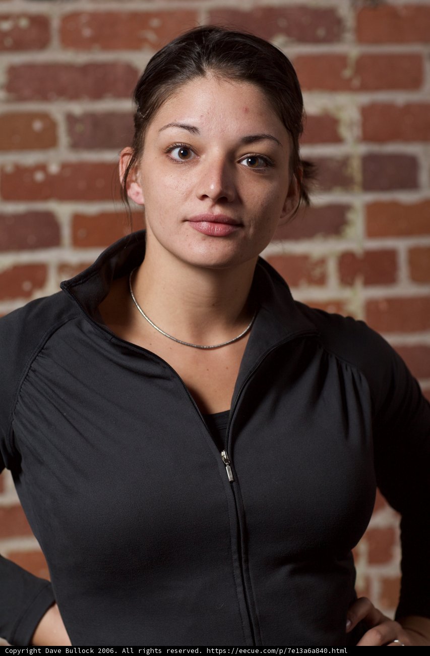 Happy Woman Poses in front of Brick Wall