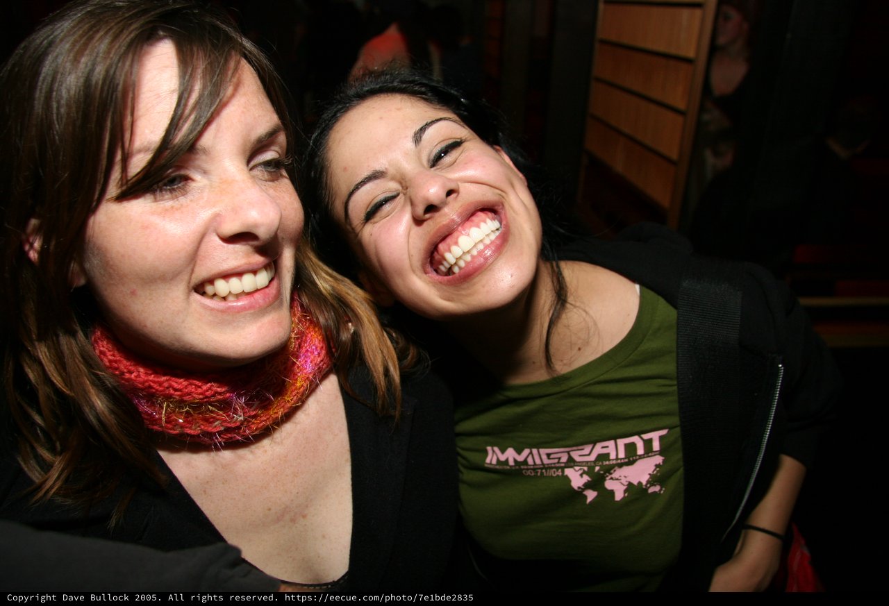 Two Friends Laughing Together at a Night Event