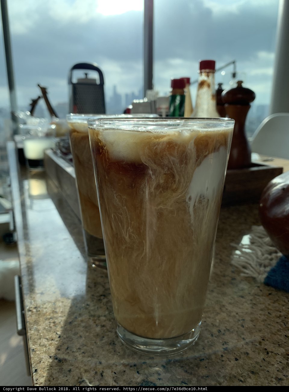 Two glasses of iced coffee on a wooden counter