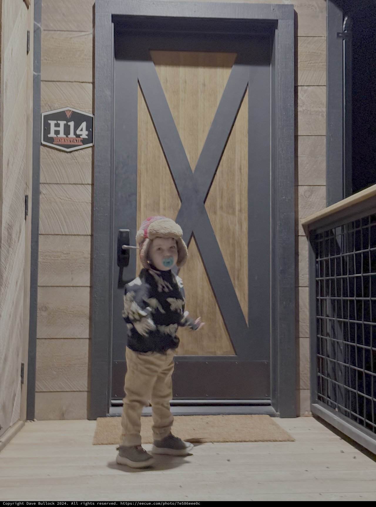 Young Child in Winter Gear at Modern Door