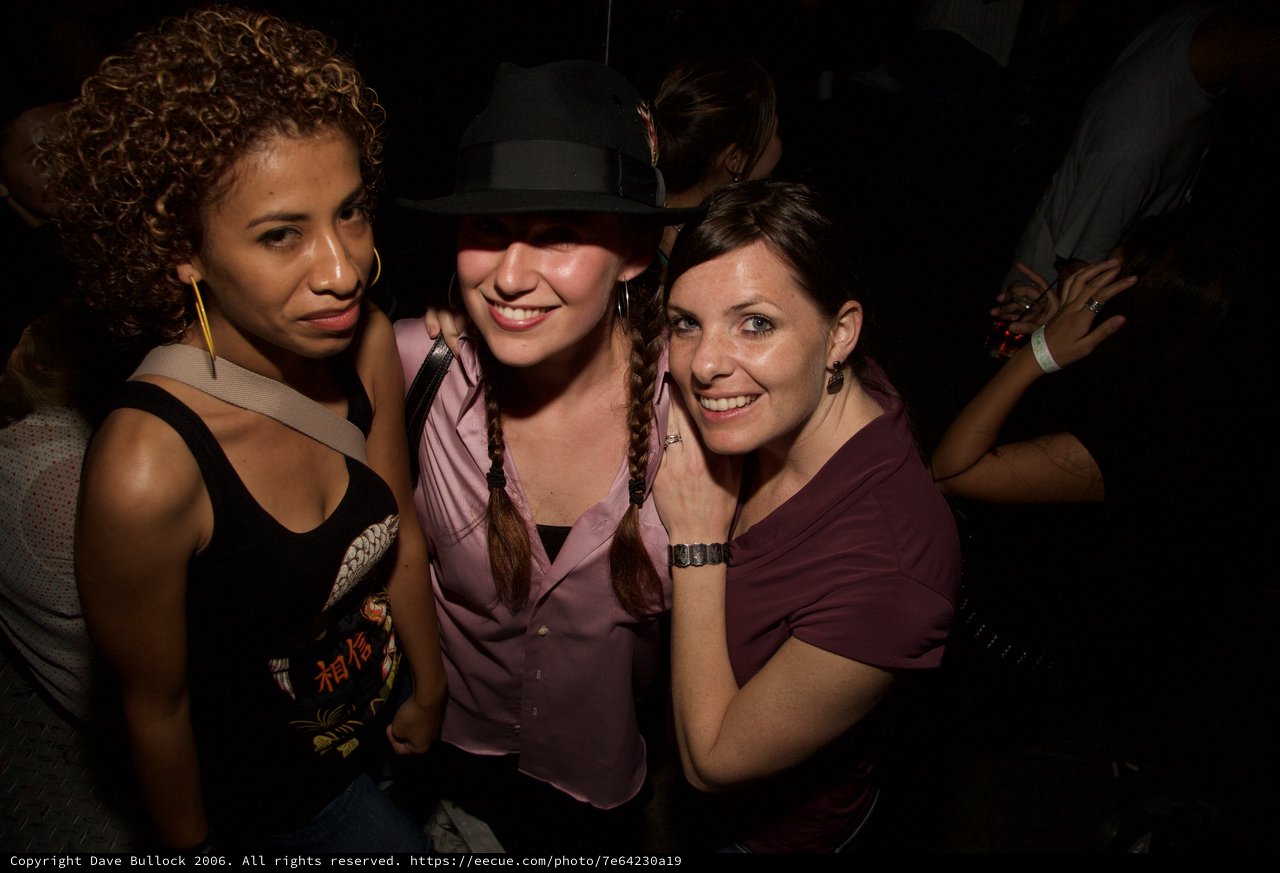 Three Friends Posing Together at a Nightclub Event