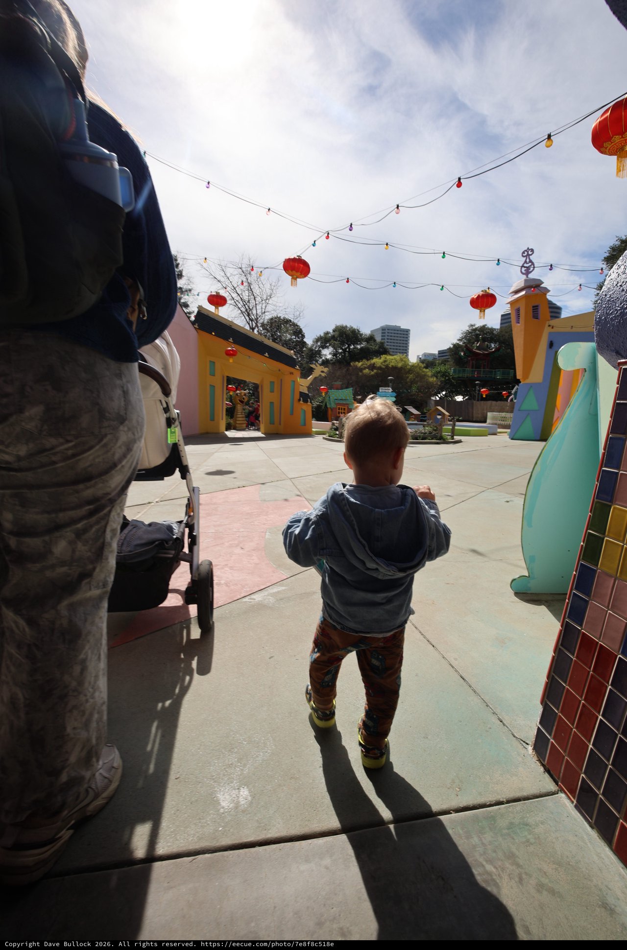 Young Child Exploring Colorful Plaza with Red Lanterns