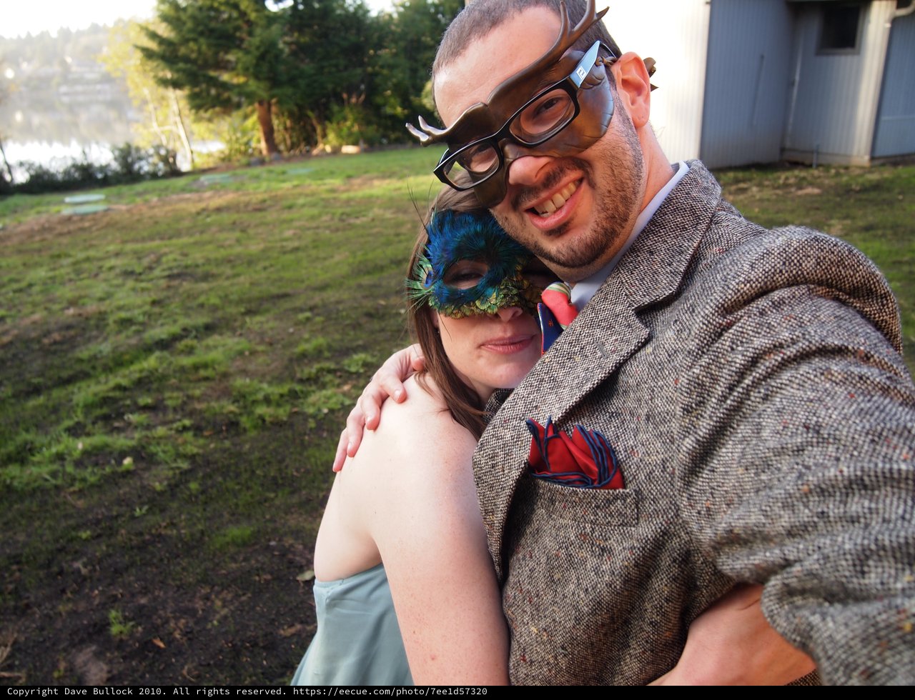 Masked Couple Embracing at Outdoor Masquerade Gathering