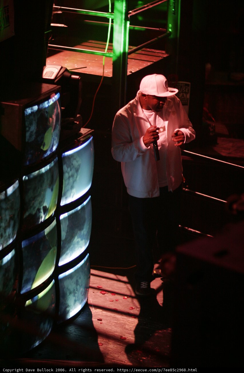 Man in Sun Hat Standing in Front of Large Screen
