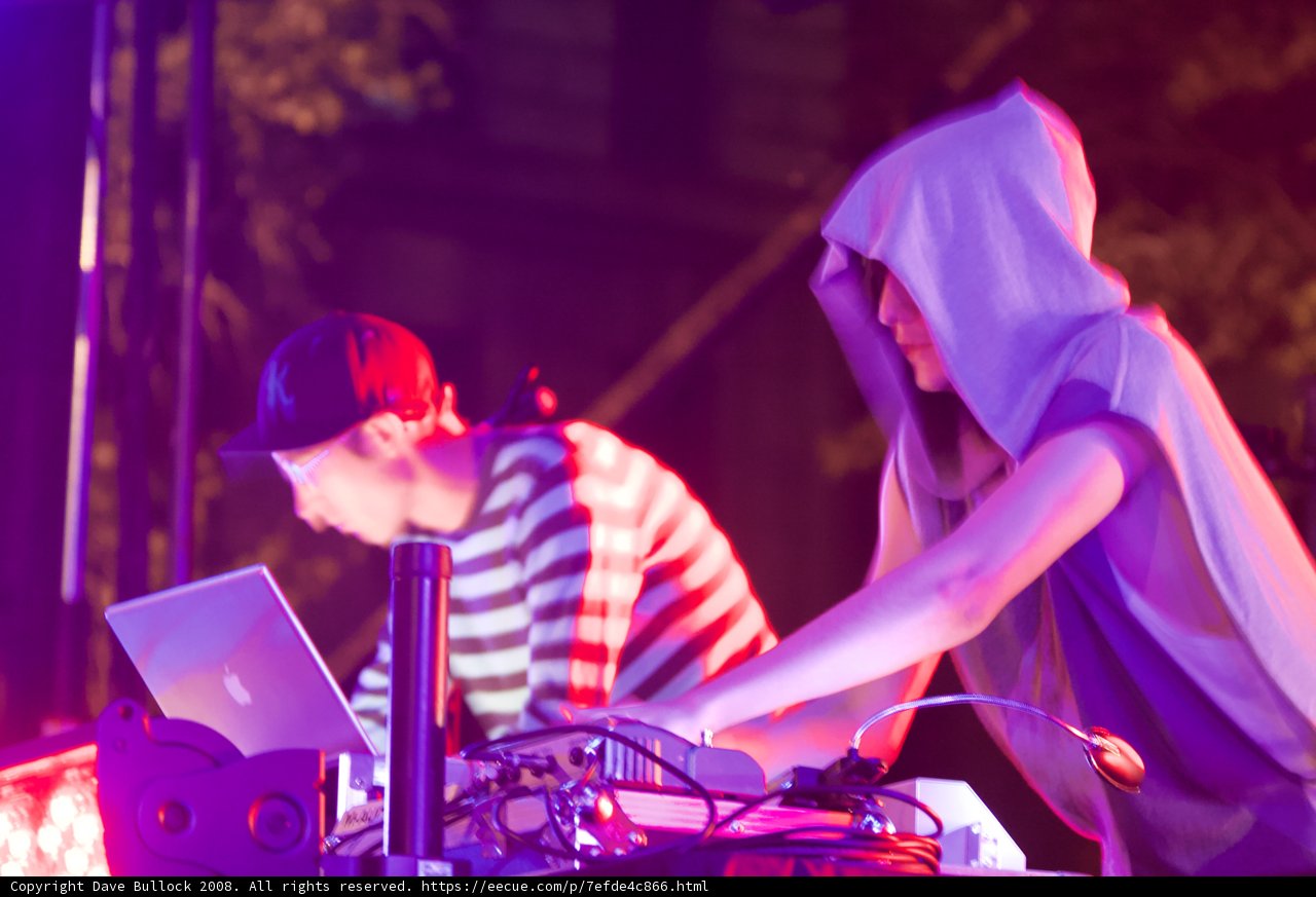 Hoodie and Laptop in a Crowded Club