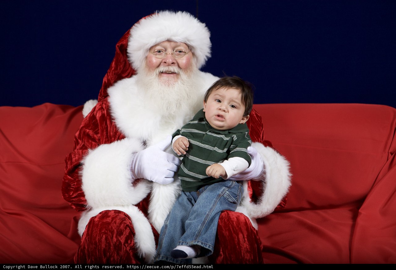 Santa Claus and Child on Festive Red Couch