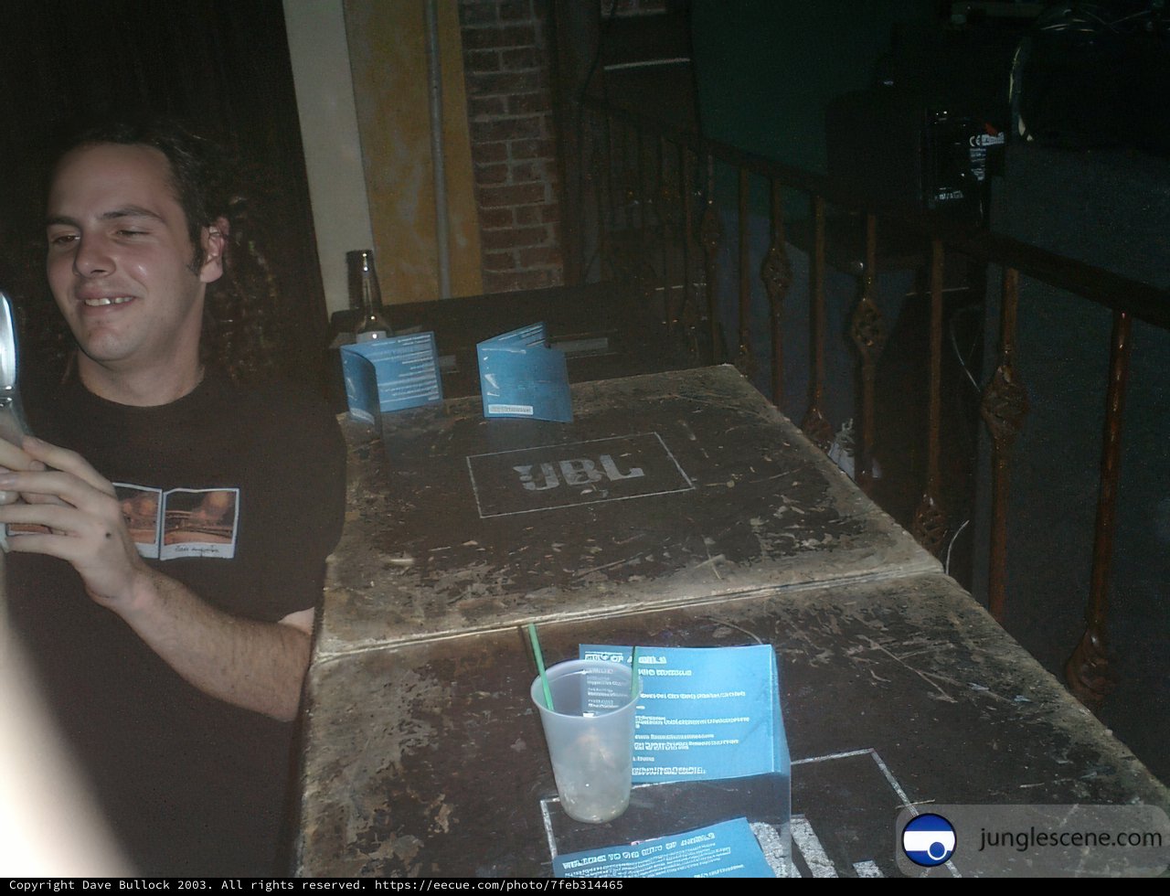 Man Checking His Phone at the Dining Table.