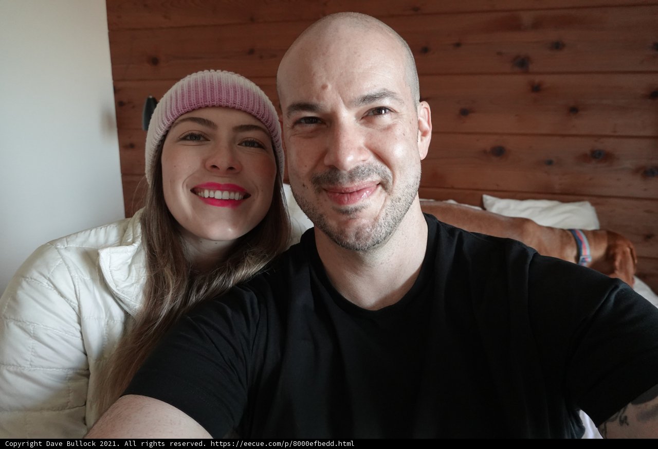 Happy Couple Takes Selfie in front of Wall