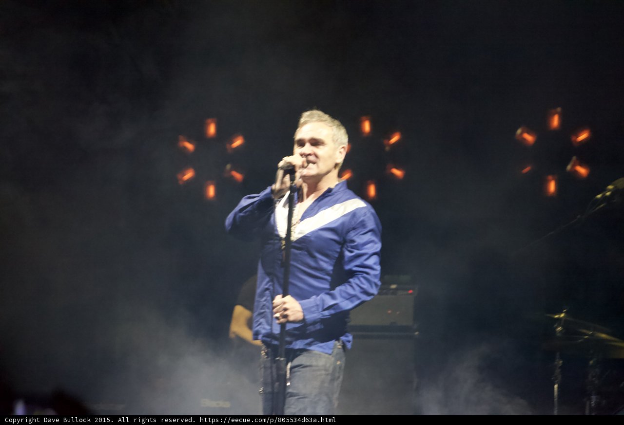 Morrissey Singing Full Body Blue Shirt White Stripe Orange Red Lights Circle Pattern Haze