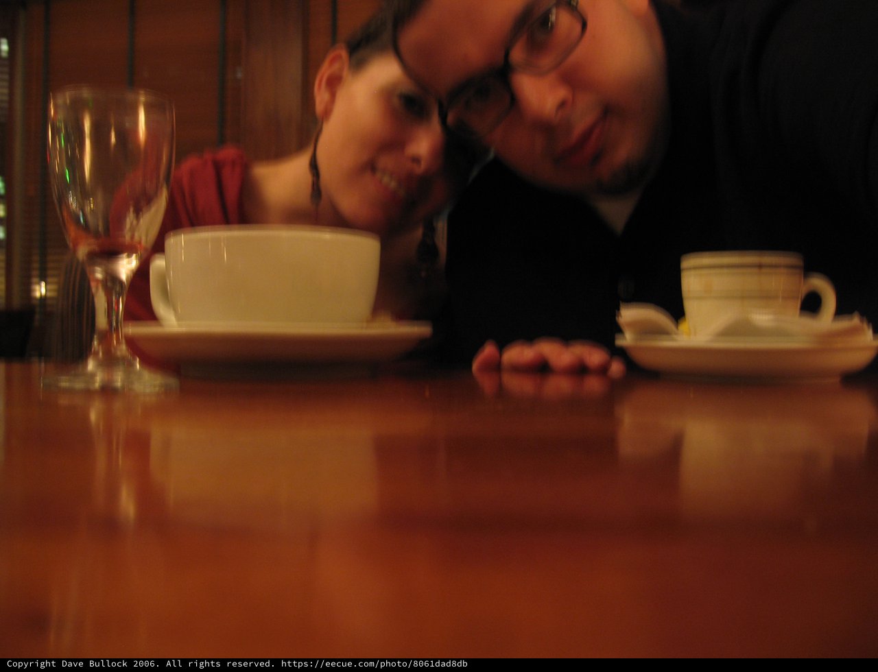 Couple Leans In Close at Cozy Restaurant Table