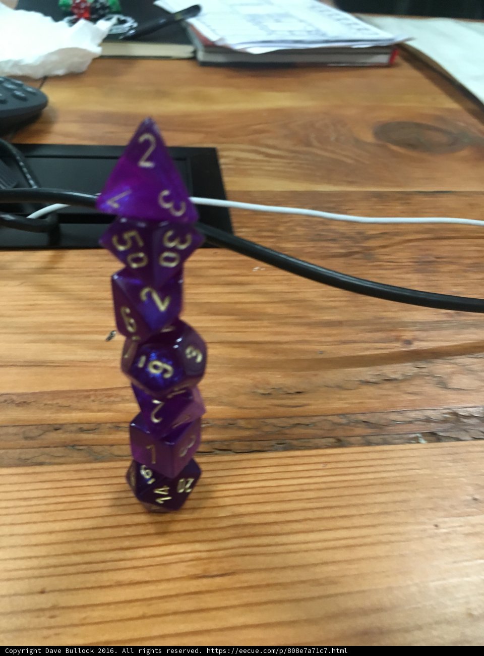 Purple Dice Emblem on Hardwood Table