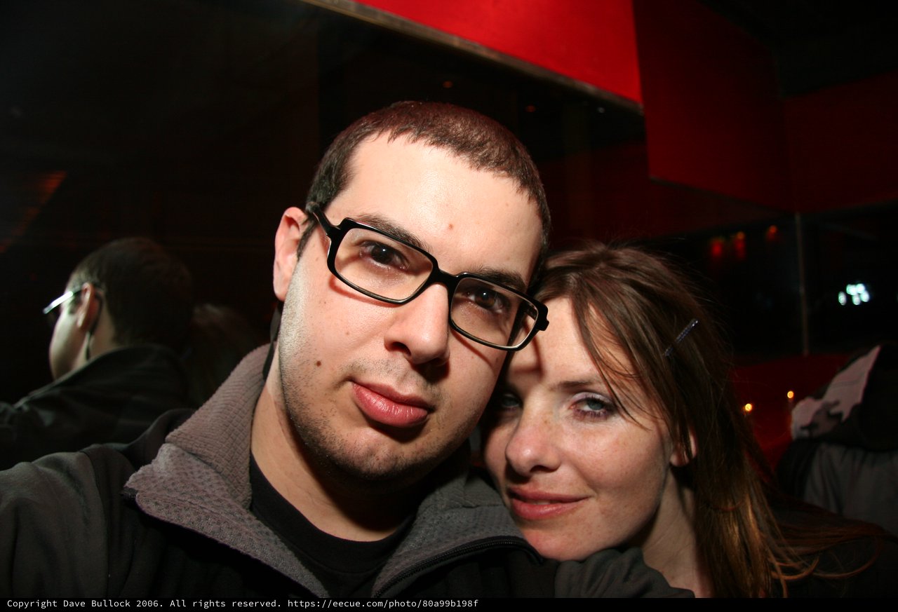 Two Friends Pose Closely at a Dimly Lit Venue