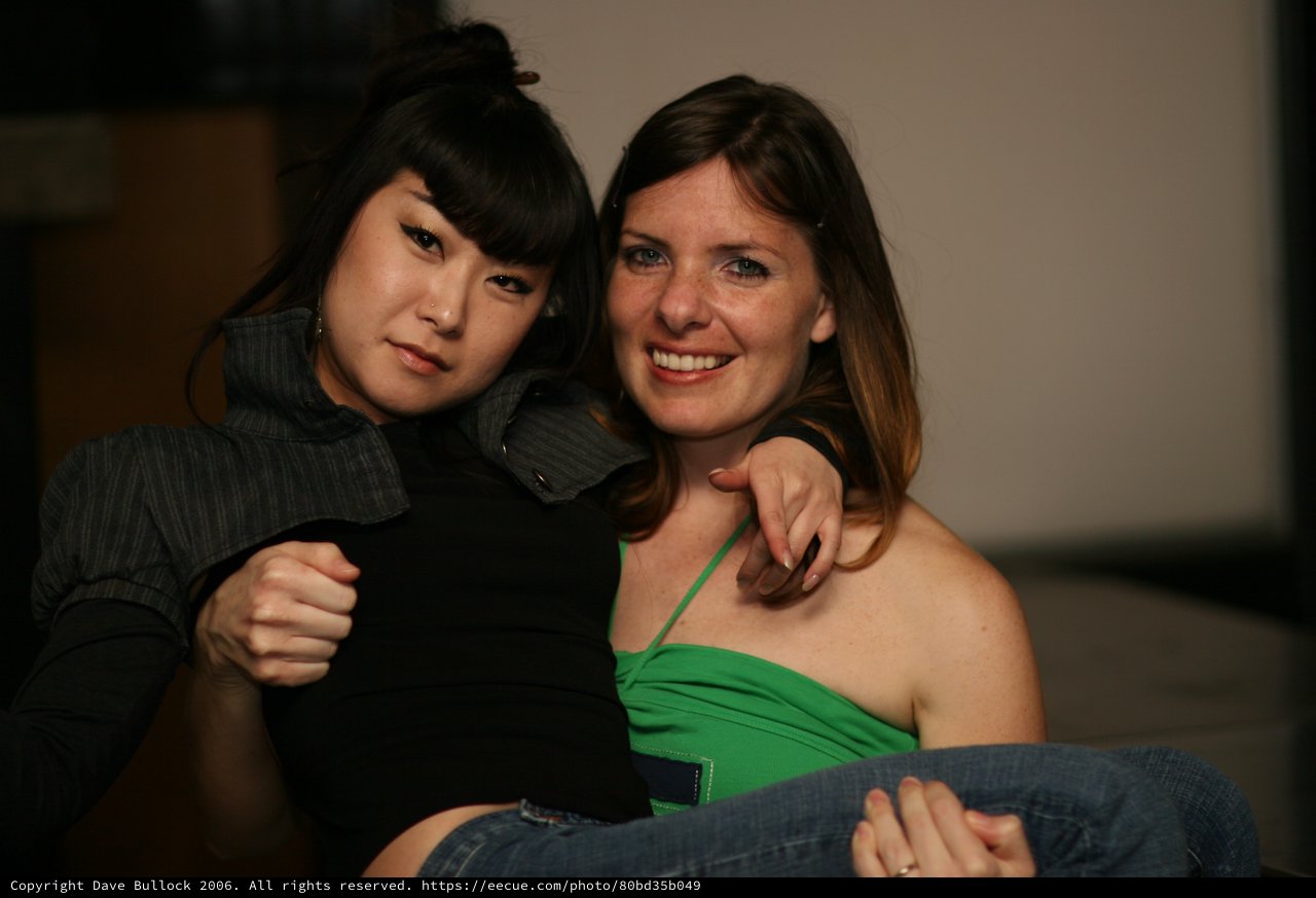 Two Friends Posing Together at Indoor Gathering
