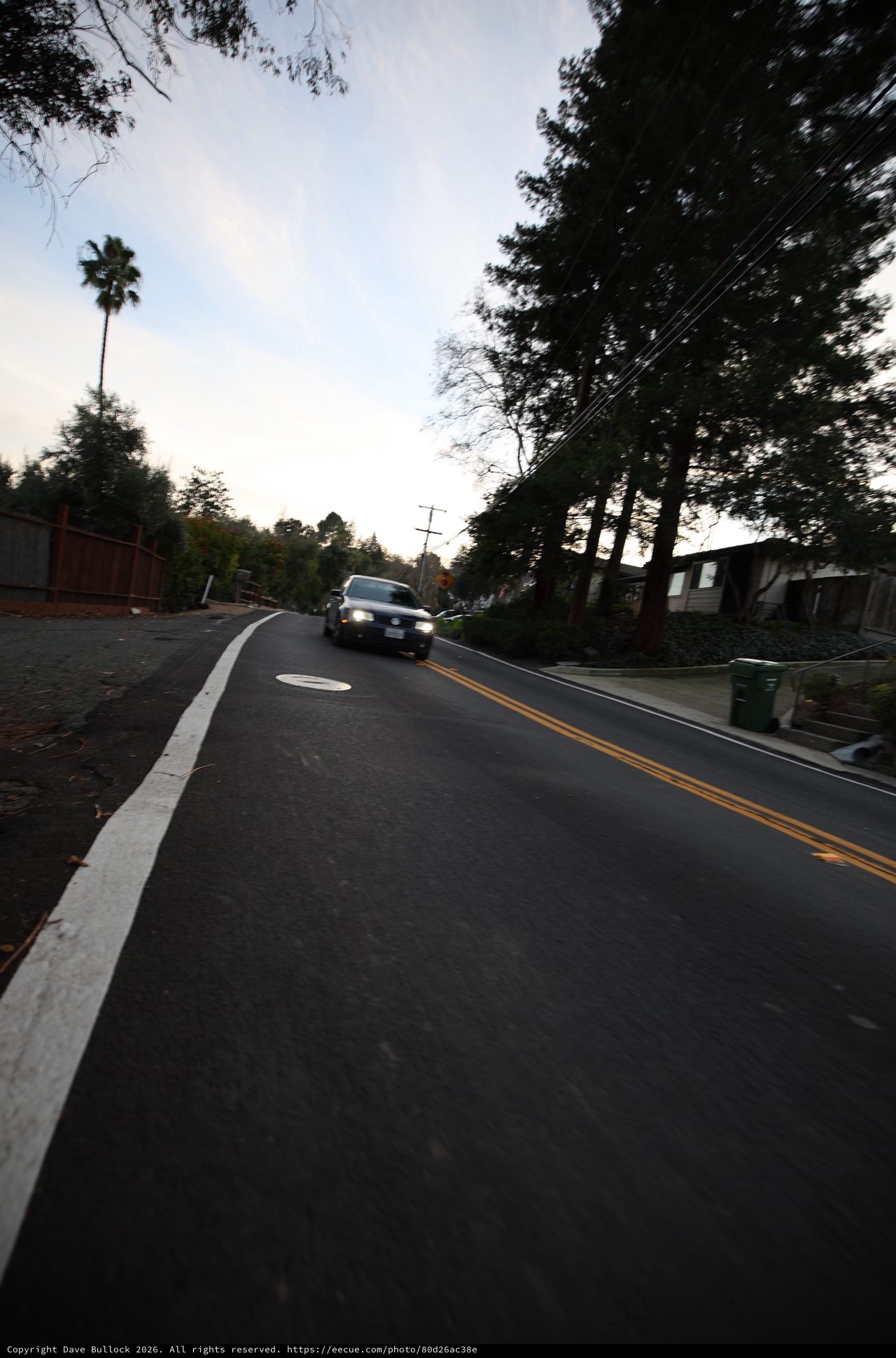 Residential Street at Dusk with Approaching Vehicle