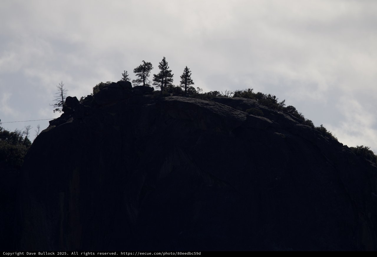Silhouetted Rocky Summit Against Overcast Winter Sky