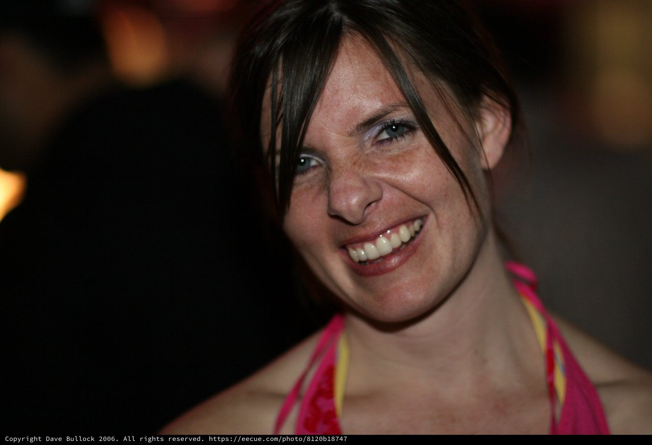 Radiant Smile of a Woman at a Nighttime Gathering
