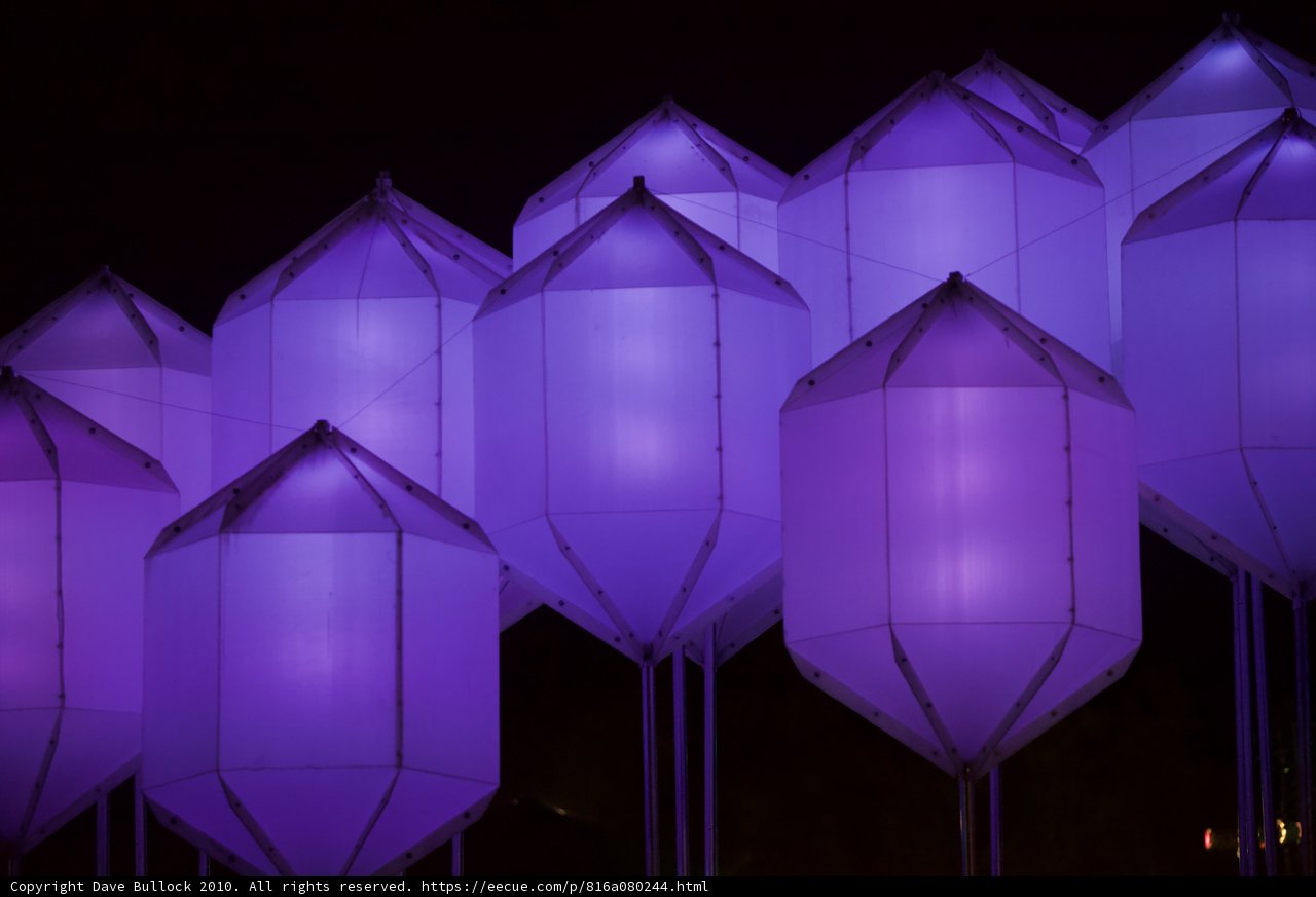 Illuminated Purple Kites Dance in the Night Sky