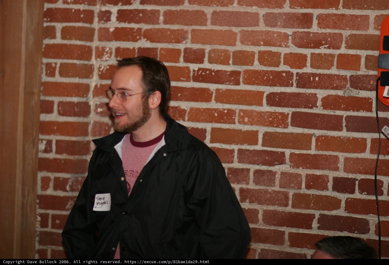 Man in Black Jacket Poses by Brick Wall