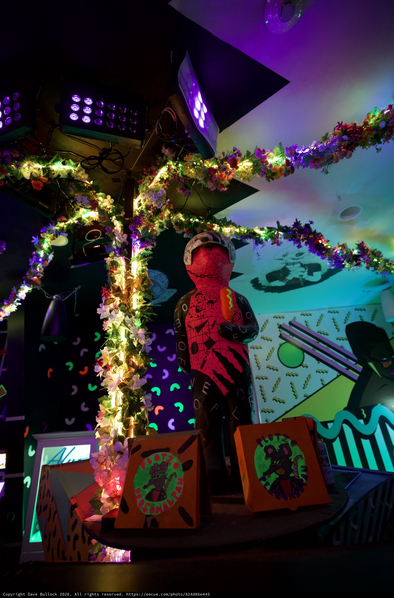 Vibrant Art Installation with Illuminated Floral Garlands and Projections