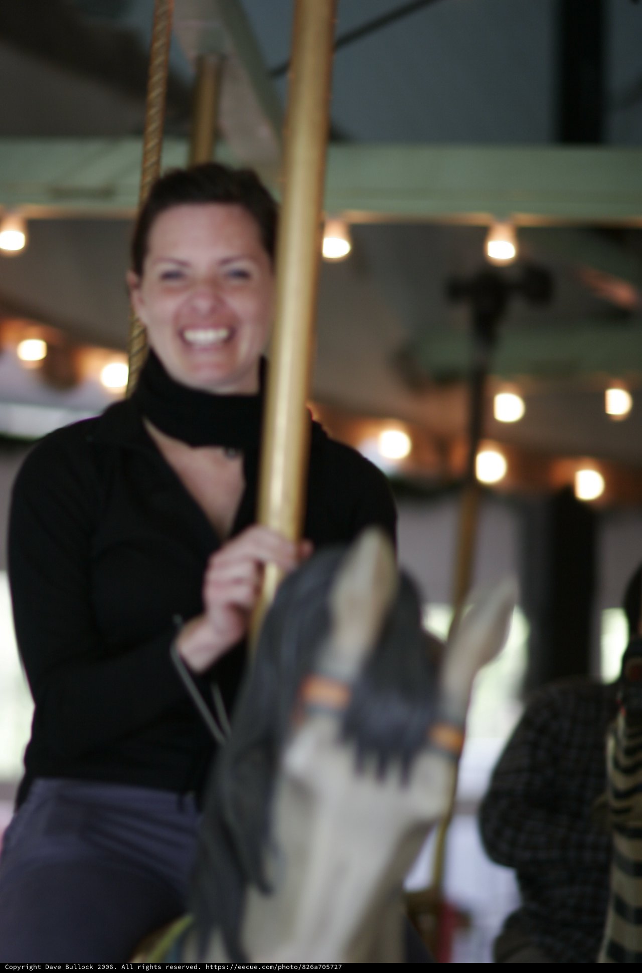 Joyful Woman Riding a Classic Carousel Horse